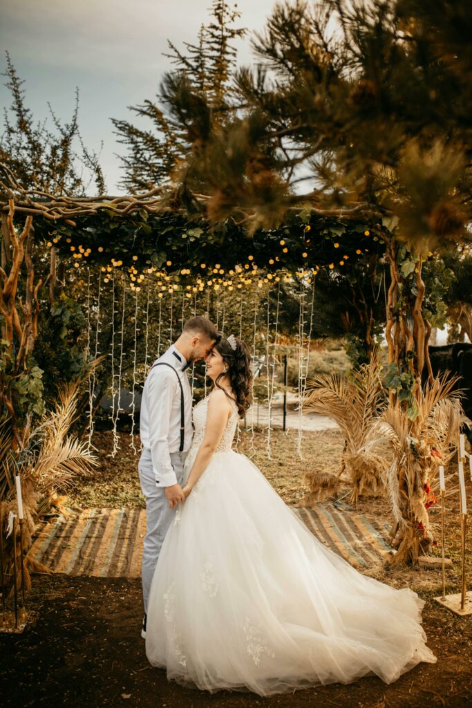 Couple de mariés sous une arche décorée lors d’une cérémonie de mariage bohème